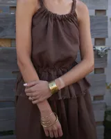 Brazalete rígido de diseño artesanal con textura irregular y acabado metálico, elaborado en bronce macizo.