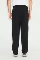 Jogger deportivo de corte relajado y piernas rectas, color negro, confeccionado en tejido funcional con tecnología DryMove. Cuenta con cintura elástica revestida con cordón de ajuste y bolsillos laterales insertados.