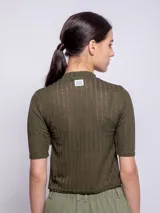 Top blanco de cuello alto y manga tres cuartos, con diseño de transparencias.