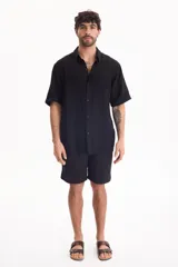 Bermuda negra de muselina con corte baggy, estilo deportivo y cordón ajustable en la cintura.