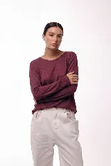 Remera de manga larga con cuello redondo, confeccionada en una mezcla de fibras naturales. Presenta un diseño básico y versátil, ideal para usar como prenda principal o como capa base.