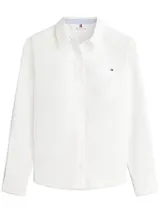 Camisa blanca de manga larga con cuello clásico, bolsillo frontal y logo bordado en el pecho. Presenta detalles distintivos de Tommy Hilfiger en el cuello.