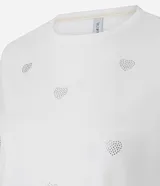 Remera blanca de algodón con cuello redondo y manga corta, con pequeños corazones bordados distribuidos por toda la prenda.