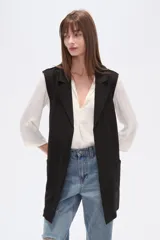 Chaleco largo de corte recto y diseño abierto, con solapas clásicas y bolsillos laterales. Confeccionado en poliéster, presenta una caída fluida y un estilo versátil ideal para superposiciones.