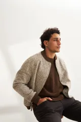 Campera estilo bomber color beige con textura, cierre delantero, cuello, puños y ruedo tejidos. Forrada, confeccionada en lana fina sin teñir.