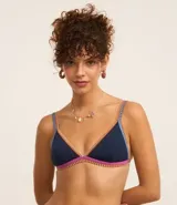 Top de bikini triangular azul marino con breteles finos y borde inferior con costuras contrastantes en fucsia y naranja.