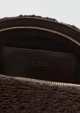 Bolso de mano tipo clutch de tamaño mediano, diseño semicircular en tejido de fibra natural color marrón oscuro. Cuenta con asa de mano lateral en cordón con cuenta de madera y cierre de cremallera.