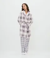 Bata de baño de corte regular confeccionada en tejido fleece suave y cálido. Presenta un diseño estampado a cuadros en tonos lila y blanco, con cuello solapa, cierre frontal mediante lazo ajustable a la cintura, mangas largas y bolsillos laterales.