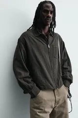 Sobrecamisa de hombre con cuello solapa, manga larga terminada en puño con botón y bolsillo de plastrón en el pecho. Cierre frontal con cremallera.