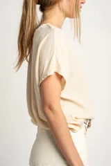 Blusa color crema de poliéster con mangas cortas y corte holgado.