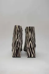 Botas plateadas de cuero con caña media, cierre lateral con cremallera, punta cuadrada y tacón geométrico de madera.