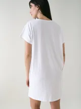 Camisón blanco de algodón, de corte holgado, manga corta y largo por encima de las rodillas. Presenta una pequeña estampa localizada en el pecho y aberturas en los laterales.