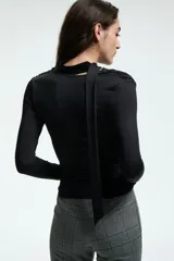 Remera de manga larga confeccionada en punto elástico, con ajuste entallado, cuello drapeado y tiras anchas integradas para variar el estilismo.