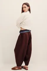Pantalón babucha negro de lino, de corte holgado estilo barrel con pinzas en la cintura y bolsillos laterales.
