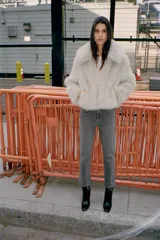 Jeans de tiro alto color marrón oscuro con acabado lavado, corte recto/flare y bajo cropped sin costuras. Presenta cinco bolsillos y cierre frontal con cremallera y botón metálico.