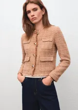Chaqueta de tweed color tostado con cuello redondo, manga larga, cuatro bolsillos de parche con solapa en la parte delantera y cierre de botones con efecto joya. Presenta terminaciones deshilachadas y forro interior.