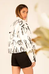 Short de jean negro con strass colgando en la pierna derecha.