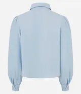 Camisa de crepé color negro, con cuello inglés, cierre frontal abotonado y mangas largas abullonadas con puños ajustados.