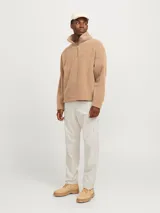 Pantalón cargo color beige de corte relajado, con cierre de gancho y cremallera, bolsillos traseros, frontales y laterales, tiro medio y detalle de cordones en los dobladillos.