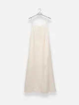 Vestido largo de color celeste confeccionado en tejido arrugado liviano. Presenta un diseño con escote recto, breteles finos y detalles de lazos en los laterales. Incluye bolsillos laterales, forro interno corto y un ruedo asimétrico con caída posterior más larga.