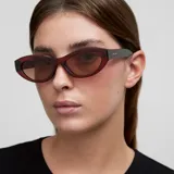 Gafas de sol con montura de acetato color borgoña (maroon) de forma ovalada/cat eye suave. Las lentes son polarizadas de color marrón.