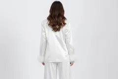 Blazer blanco de satén con solapas clásicas, cierre frontal de botones y puños decorados con plumas blancas. Presenta un corte estructurado y elegante.