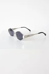 Lentes de sol con armazón metálico plateado y diseño hexagonal. Cuentan con protección UV400 y patillas con el logo de la marca grabado.