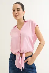 Camisa rosa de viscosa con cuello camisero y mangas cortas. Se anuda en la parte delantera.