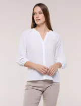 Blusa de gasa de color lila con calce holgado, cuello a la base con escote en V y cartera de botones a tono. Cuenta con fruncidos en el cuello y hombros que otorgan volumen, manga tres cuartos estilo abullonado con puño elastizado y ruedo suavemente redondeado.