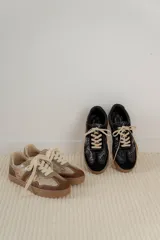 Championes urbanos de diseño acolchado, combinando tonos marrones, beige y detalles metalizados con textura. Cuentan con cordones al tono y suela de goma color caramelo.