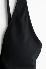Soutien suave de punto seamless color negro, con escote en V profundo, tirantes ajustables y banda elástica ancha en la base para mayor sujeción.
