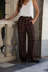Pantalon de corte amplio y tiro alto, con diseño de cuadros en tonos oscuros, cintura con presillas y bolsillos laterales.