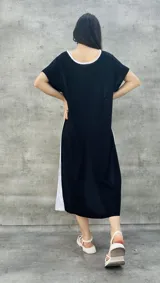 Vestido largo blanco con mangas cortas negras y corte holgado.