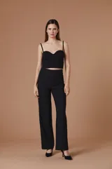 Pantalón de vestir negro de corte recto y tiro alto, con diseño de silueta amplia y caída fluida.