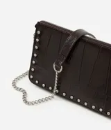 Cartera bandolera Satinato de color marrón oscuro, confeccionada en poliuretano con textura geométrica símil cocodrilo y detalles de tachas metálicas plateadas en los bordes. Cuenta con cierre superior y correa larga de cadena metálica.