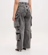 Pantalón de jean con corte recto y efecto desteñido, caracterizado por sus bolsillos cargo funcionales en los laterales y pences en las rodillas. Presenta un diseño utilitario y moderno con cierre frontal y bolsillos clásicos.