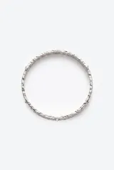 Pulsera rígida de metal plateado con acabado texturizado y pequeños cristales incrustados a lo largo de toda la pieza.