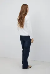 Remera de manga larga en color azul marino, confeccionada en tejido suave. Presenta un delicado detalle de bordado festoneado en color blanco tanto en el cuello redondo como en los puños, aportando un toque distintivo a esta prenda básica.