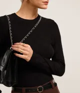 Suéter negro de punto con cuello redondo y manga larga, con textura geométrica de losangos.