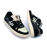 Championes urbanos Öus modelo Cuoro, con diseño de estilo skate en combinación de colores negro y crema. Presentan paneles laterales con logo distintivo, puntera perforada y suela de goma plana en tono crema.