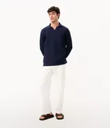 Remera de manga larga color marrón, confeccionada en tejido texturizado con cuello en V tipo polo. Presenta un diseño de calce confortable y acabado moderno.