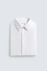 Camisa de corte slim fit confeccionada en tejido de algodón. Presenta cuello italiano, manga larga con puños abotonados y cierre frontal mediante botonadura clásica.