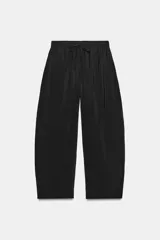 Pantalón fluido confeccionado en mezcla de modal, de tiro medio con cintura elástica ajustable con cordón y bolsillos laterales, en color tostado.