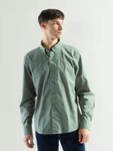 Camisa de manga larga confeccionada en algodón, con cuello abotonado y cierre frontal de botones. Presenta un diseño clásico y versátil con un pequeño logo bordado en el pecho.