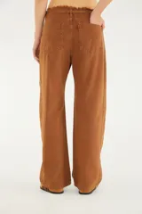 Pantalón de jean de corte recto y tiro medio color marrón, con bolsillos funcionales, lazo ajustable en la cintura confeccionado en la misma tela y detalle de acabado desflecado en el borde superior.