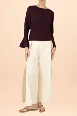 Suéter de punto color púrpura con cuello perkins, manga larga y puños acampanados. Presenta una textura sutil con acabado brillante.