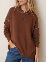 Sweater de punto color marrón con capucha, mangas largas y costuras visibles a contratono en blanco y negro. Presenta un parche bordado con el logo de la marca en el centro del pecho.