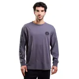 Remera de manga larga Volcom, color gris, con cuello redondo y puños acanalados. Presenta un pequeño logo circular estampado en el pecho y el nombre de la marca estampado verticalmente a lo largo de la manga derecha.