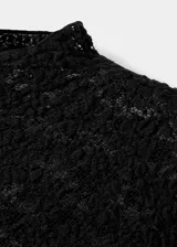 Top de encaje negro con cuello perkins, diseño entallado y manga larga.