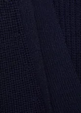 Cardigan de punto en color azul marino, con cuello en pico, cierre frontal de botones y diseño oversize de corte largo con mangas largas.